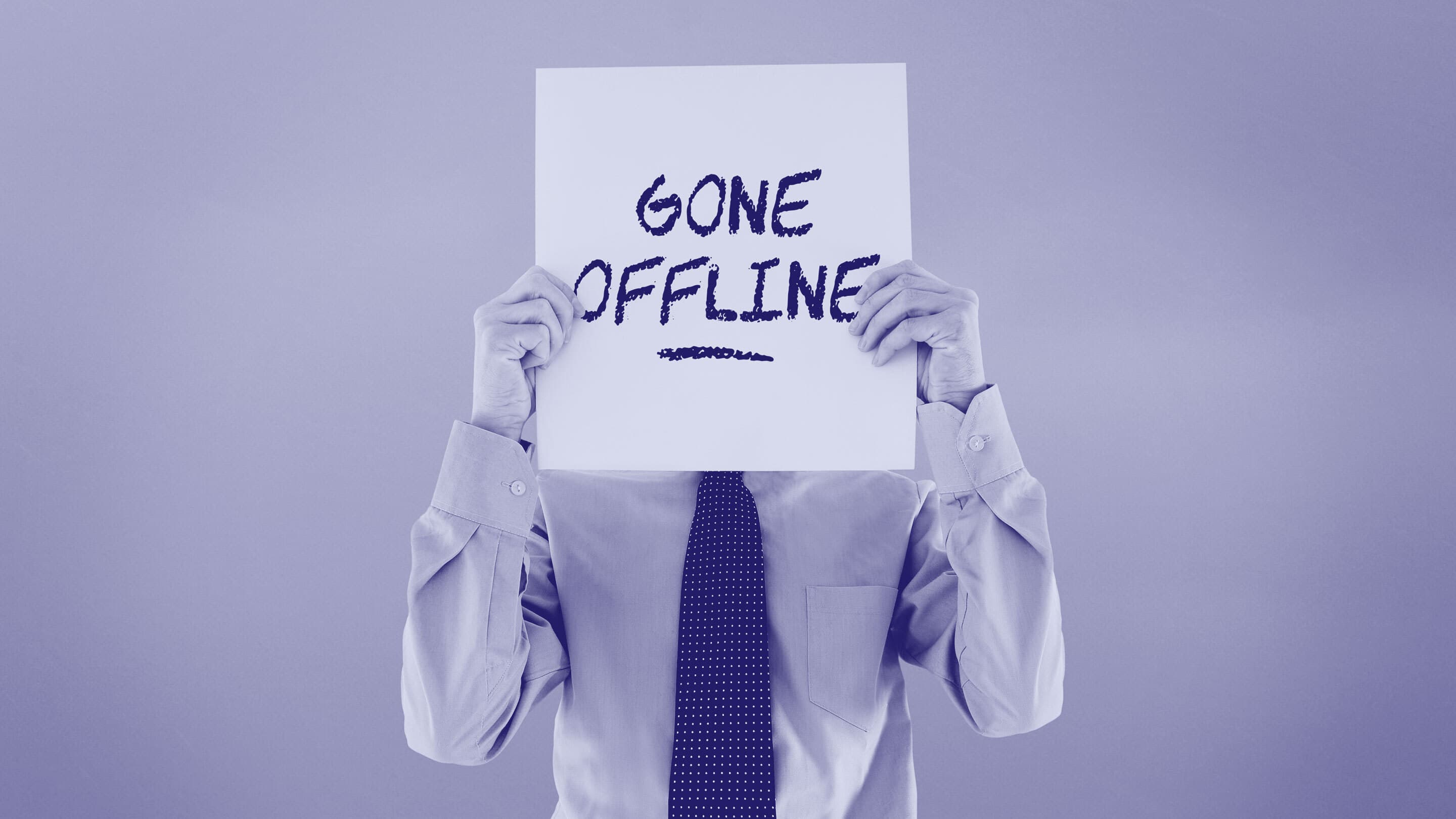 Business executive holding sign in front of face that says gone offline.