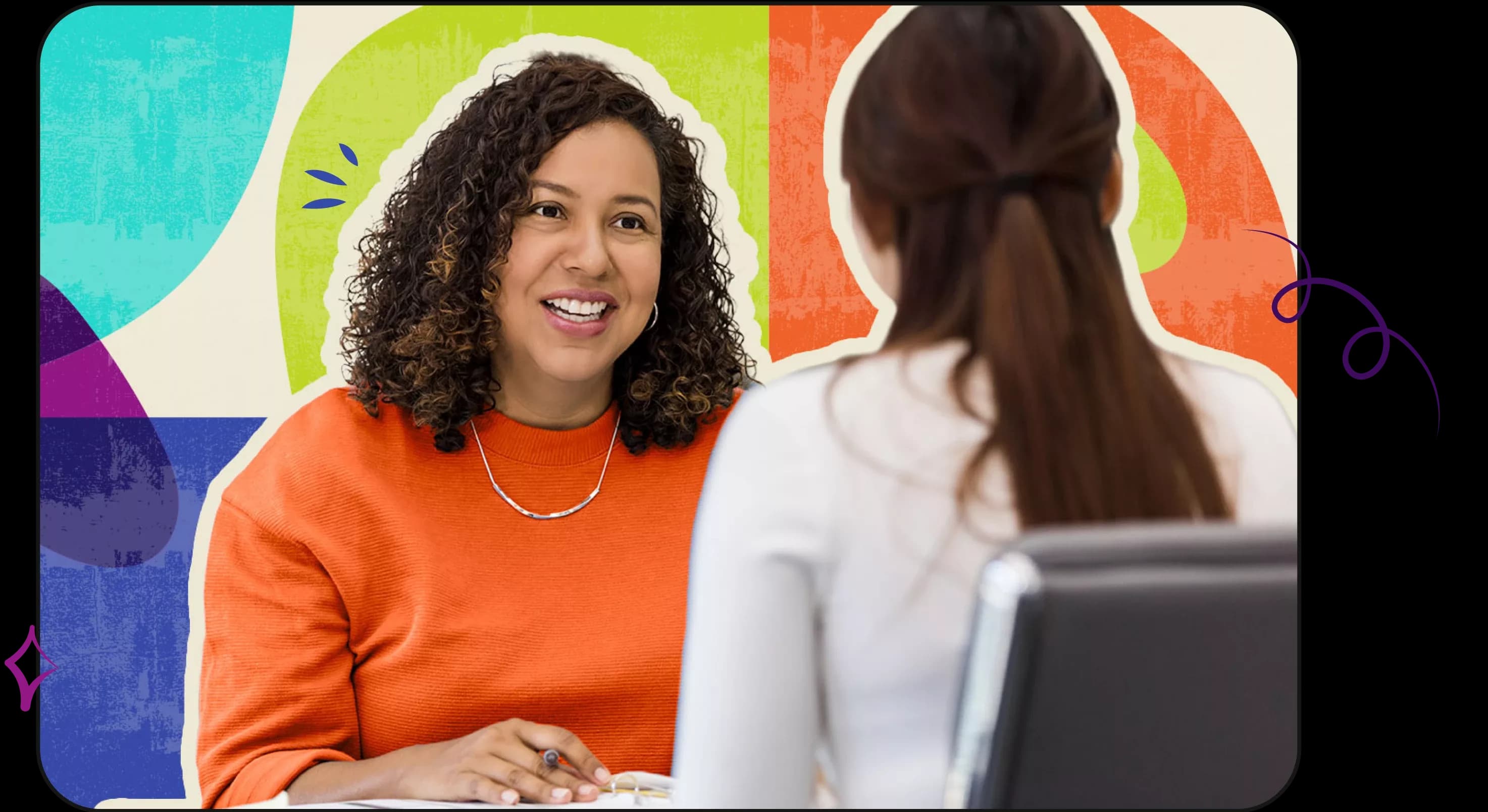 Hispanic woman and Asian woman across desk from one another working together and talking earnestly